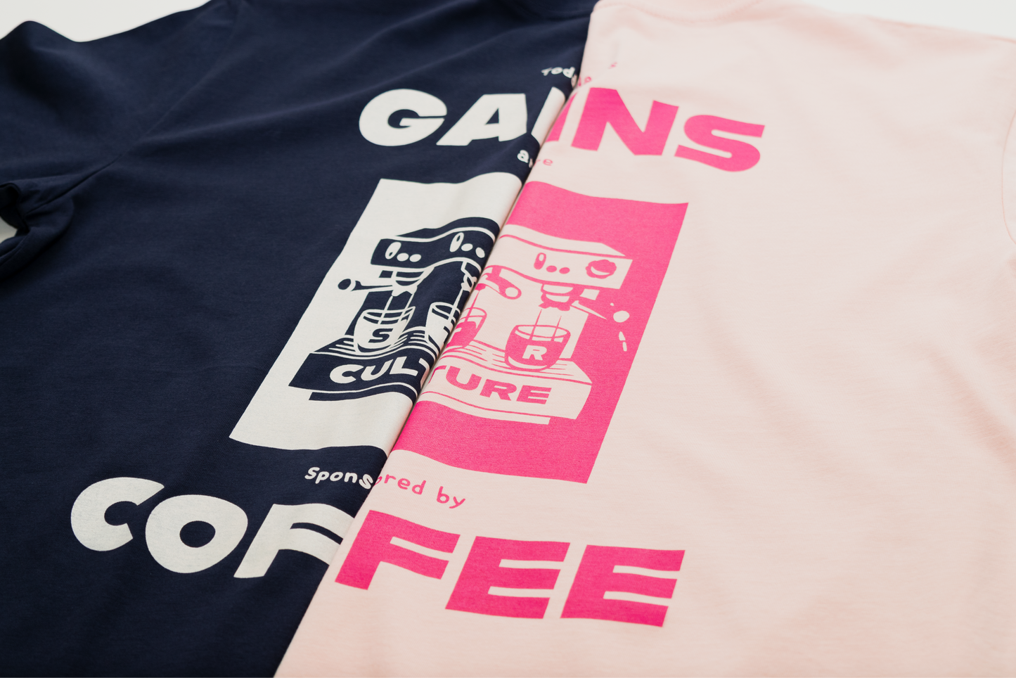 Two t-shirts with graphic designs and text on a neutral background