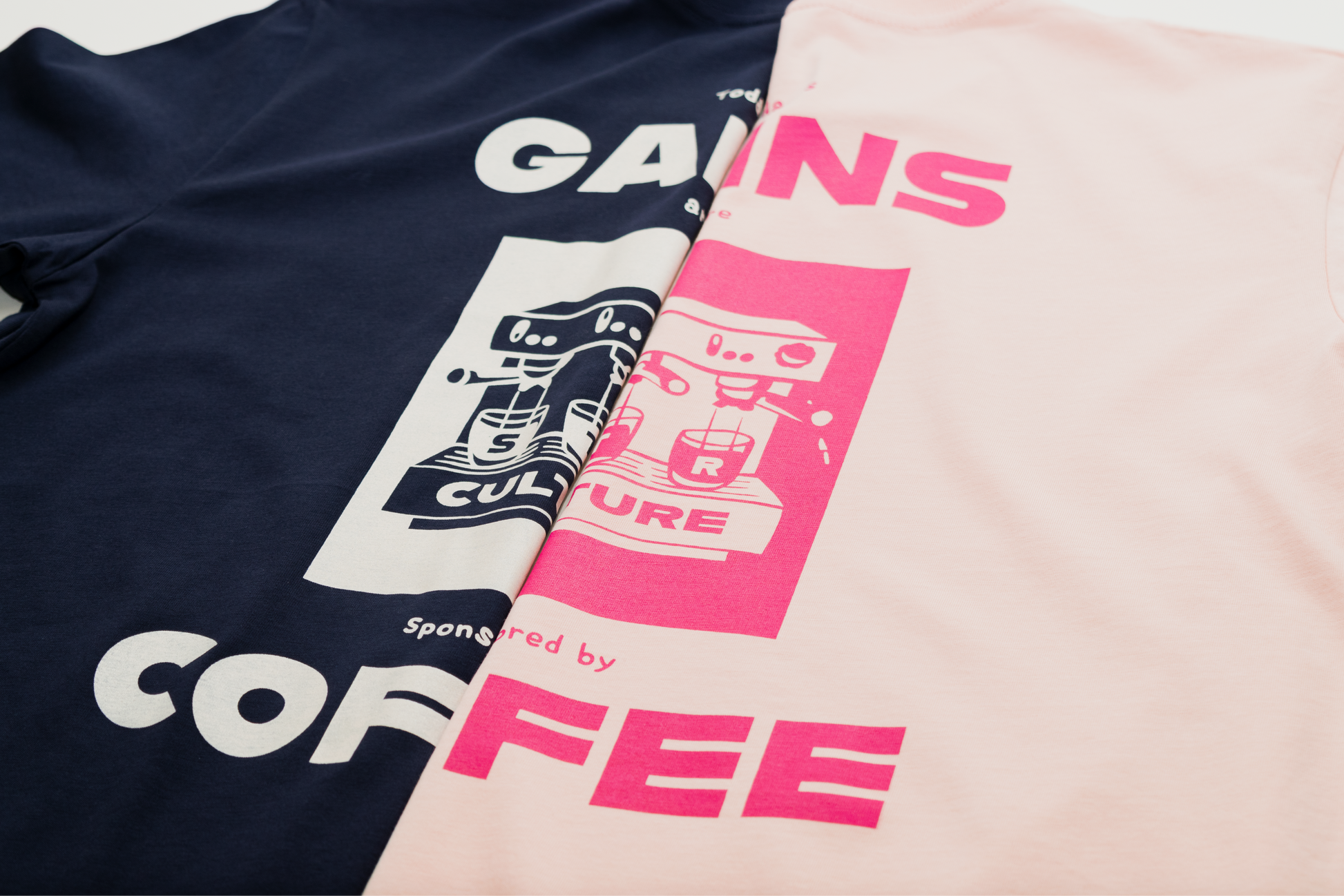 Two t-shirts with graphic designs and text on a neutral background